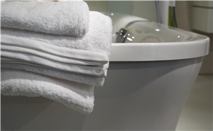 Ein Stapel weißer Handtücher auf einer Badewanne. Ein Stapel weißer Handtücher auf einer Badewanne.