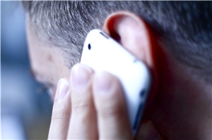 Ein Mann hält ein Handy ans Ohr. 
