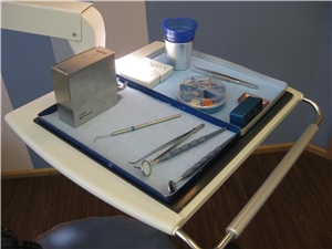 Instrumente für eine zahnärztliche Behandlung auf dem Schwenktisch, der am Zahnarztstuhl angebracht ist. 