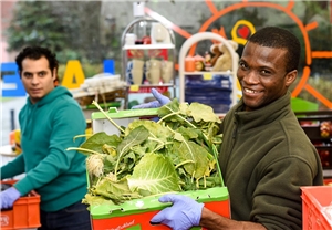 Zwei Flüchtlinge tragen Gemüsekisten