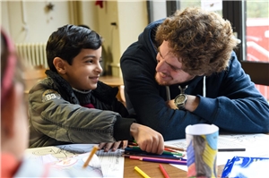 Flüchtlingskind mit deutschem Begleiter Ausländisches Kind in der Schule mit deutschem Begleiter