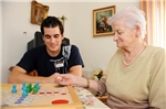 HOP_8872 alte Dame mit jungem Mann bei einem Brettspiel
