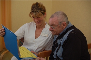 Eine Pflegekraft bespricht mit einem Bewohner die Pflegeplanung