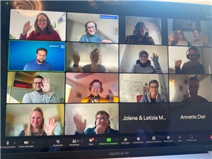 Bildschirm eines Computers, auf dem ganz viele Gesichter während eines Online-Meetings zu sehen sind. 