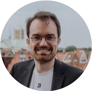 Portrait eines Mannes mit dem Dom von Münster im Hintergrund.