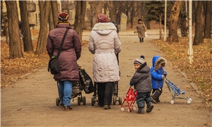 Frauen auf dem Weg 2 Frauen mit Kinderwagen, 2 Kinder mit Buggy auf winterlichem Weg im Park