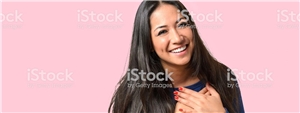 Frau mit Händen am Herzen rosa Hintergrund Frau mit Händen am Herzen rosa Hintergrund