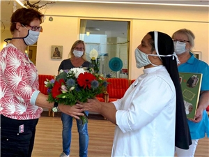 Ordensschwester bekommt einen Blumenstrauß