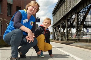 Kids on Tour - eine Mitarbeiterin mit einem kleinen blonden Jungen am Bahnhof