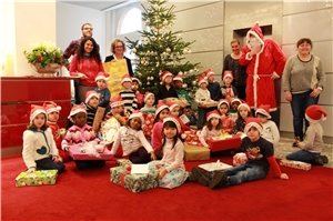 Ernst & Young Mitarbeiter verteilen Päckchen an Kinder der Kita St. Godehard