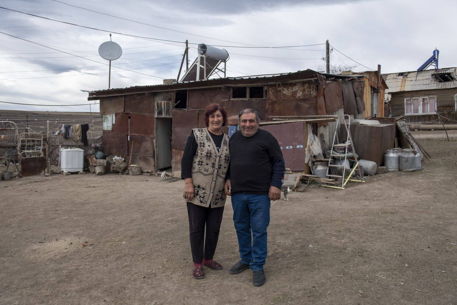 Geflohenes Ehepaar vor provisorischem Haus, nach Flucht von ihrem Heimatort in Armeinien