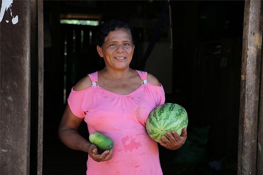 Eine Frau mit einer Wassermelone und weiterem Gemüse in den Händen