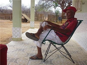 Ein Mann sitzt auf einem Stuhl auf einer Veranda