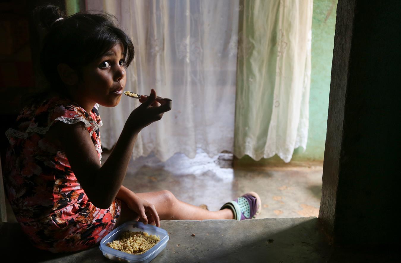 Venezuela: Mädchen isst Reis mit Hackfleisch