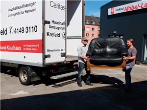 Umzugshilfe zwei Männer die ein Sofa aus einem LKW laden