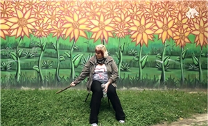 Kurzfilm Frau steht vor bemalter Wand