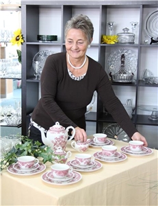Eine Mitarbeiterin arrangiert ein Teeservice