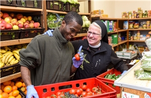 Das Foto zeigt eine Ordensschwester und einen Afrikaner in einem Lebensmittelladen.