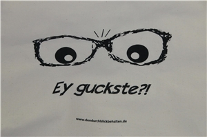 Jute-Beutel mit Brille auf Aufschrift 'Ey guckste' bedruckt.