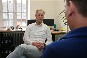 Rüdiger Jähne sitzt mit einem Klienten in seinem Büro und führt ein Beratungsgespräch.
