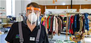 Ein Mann in Arbeitskleidung mit Schutzvisier und Atemmaske steht in den Räumen der Duisburger Werkkiste