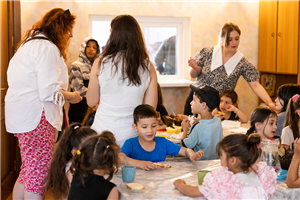 Einige Kinder sitzen im Kinder- und Jugendzentrum der Caritas Georgien an Tischen und essen
