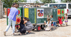 Eine mobile Schule (Anhänger mit Tafeln), der am Rande von Tiflis in Georgien aufgestellt ist und von einigen Kindern besucht wird 