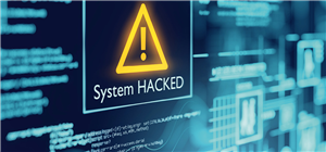 Ein Bildschirm mit Codes und Grafiken in blauer Farbe, auf der die gelb gefärbte Warnmeldung 'System HACKED' steht