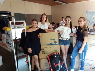 Schule als Staat Kleiderkreisel Vier Schülerinnen vor Kisten voll mit Kleidung