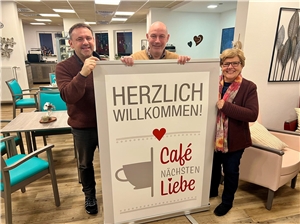  Agnes Schug-Speyerer, Rainer Lehmler und Heiko Hastrich mit dem Willkommens-Schild vom Café Nächstenliebe.