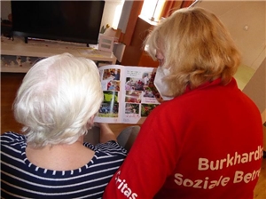 eine Burkhardhausbewohnerin und Frau Ackermannn beim Lesen in der Heimzeitung
