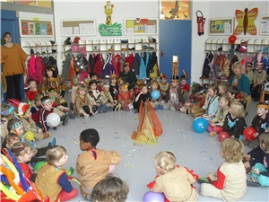 Kinder sitzen als Indinaer verkleidet im Kreis auf dem Boden.