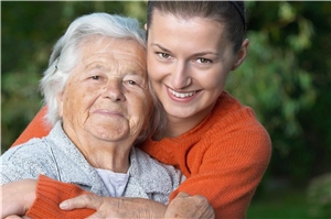 Sprechstunde Junge Frau umarmt ältere Frau von hinten.