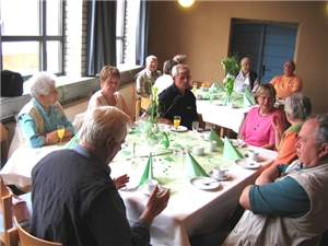 Caritaszentrum Alzey Mehrere ältere Menschen sitzen um eine Tisch und trinken Kaffee.