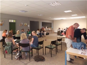 Die Mitarbeiter sitzen oder stehen im Raum und diskutieren. MFT-Workshop