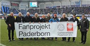 Vertreter von Land, den Kommunen, Polizei und dem SC Paderborn  halten ein Banner mit der Aufschrift 'Fanprojekt Paderborn' hoch