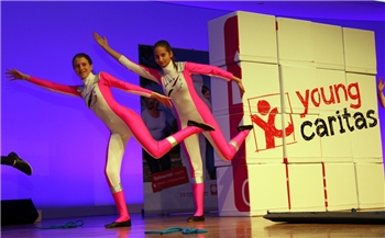 Logo youngcaritas wird auf Bühne gezeigt