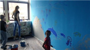 Drei Kinder und eine blaue Wand
