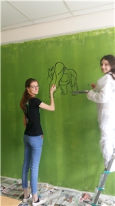 Mädchen bemalt grüne Wand