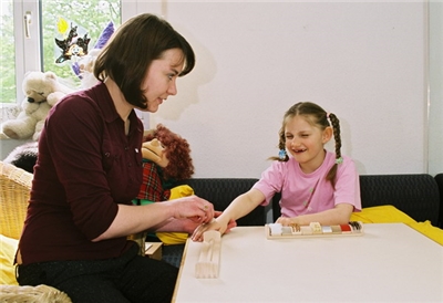 Frau sitzt mit Kind am Tisch 
