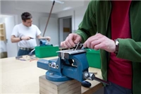 Wohnverbund_Haus_Agathaberg_QUANTUM Zwei Bewohner spannen Holz in je einen Schraubstock ein, um es zu bearbeiten
