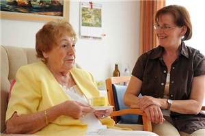 Eine ältere Dame mit einer Besucherin in ihrem Zimmer in einer Seniorenpflegeeinrichtung Eine ältere Dame mit einer Besucherin in ihrem Zimmer in einer Seniorenpflegeeinrichtung