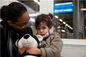 Eine Mutter hält ihr Kind bei der Bahnhofsmission im Arm