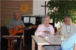 Mit seinem Gitarrenspiel leistet ein Mann einen wertvollen Beitrag zum wöchentlichen Singkreis im Katholischen Altenzentrum Landau.