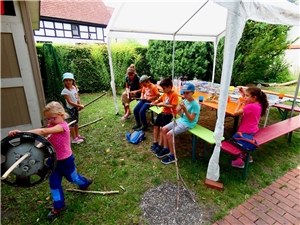 Kinder werkeln mit Stöcken