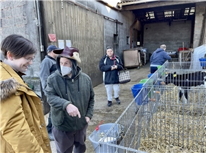 Bewohner einer Gruppe für Menschen mit Behinderung besuchen einen Bauernhof