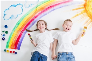 Junge  und Mädchen malen an einem Regenboge
