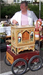 Eine ehrenamtliche Mitarbeiterin spielt beim Schnitzelfest im Caritas-Altenzentrum St. Anton auf einem Leierkasten. Eine ehrenamtliche Mitarbeiterin spielt beim Schnitzelfest im Caritas-Altenzentrum St. Anton auf einem Leierkasten.