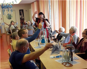 Eine Frau im Dirndl animiert die Bewohner zum Armeschwenken. Oktoberfest 1