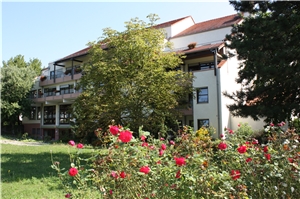 Das Altenzentrum St. Elisabeth, Deidesheim, vom Garten aus mit blühenden Bäumen, Sträuchern und Rasen Das Altenzentrum St. Elisabeth, Deidesheim, vom Garten aus mit blühenden Bäumen, Sträuchern und Rasen
